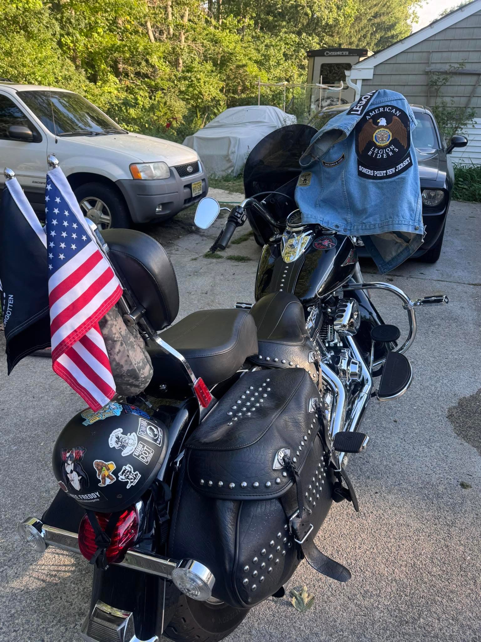 Ground-level photo of a motorcycle with an American Legion Riders vest and flags, prepared for a group ride